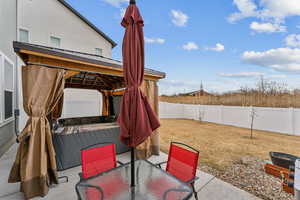 View of patio / terrace featuring a gazebo, a fenced backyard, and outdoor dining space