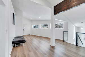 Entrance foyer with light wood-style flooring, recessed lighting, lofted ceiling with beams, and baseboards