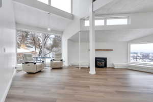 Unfurnished living room with a textured ceiling, a wealth of natural light, and wood finished floors