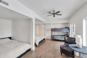 Bedroom featuring a ceiling fan, wood finished floors, visible vents, and baseboards