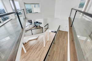 Stairway featuring a towering ceiling, wood finished floors, and visible vents