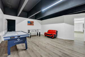 Recreation room with baseboards and wood finished floors