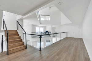 Bonus room with a towering ceiling, baseboards, and wood finished floors