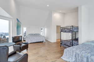 Bedroom with light wood-style flooring, baseboards, vaulted ceiling, and recessed lighting