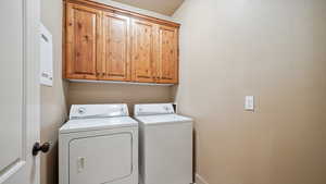 Laundry area featuring cabinet space and washing machine and dryer