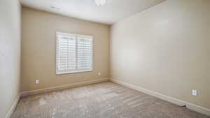Unfurnished room with baseboards, visible vents, and carpet