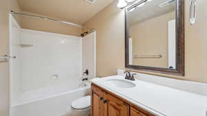 Full bathroom with visible vents, toilet, shower / tub combination, and vanity
