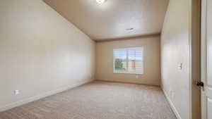 Primary  bedroom featuring carpet flooring, a textured ceiling, visible vents, and baseboards