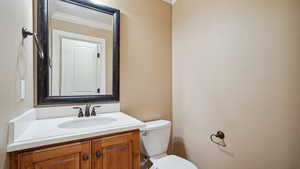 Bathroom featuring crown molding, toilet, and vanity