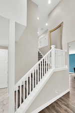 Staircase featuring recessed lighting, wood finished floors, visible vents, and baseboards