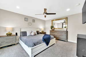 Carpeted bedroom featuring recessed lighting, a ceiling fan, and baseboards