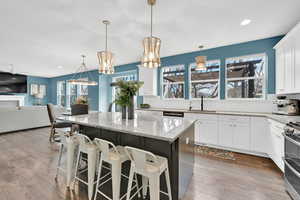 Kitchen featuring dark wood-style floors, double oven range, backsplash, and a sink