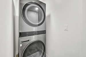 Washroom featuring laundry area and stacked washing maching and dryer