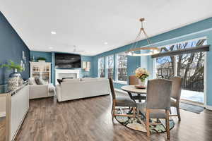 Dining space featuring ceiling fan with notable chandelier, a fireplace, recessed lighting, and hardwood / wood-style flooring