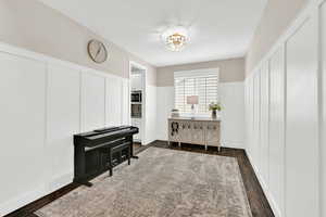 Mudroom with a wainscoted wall, visible vents, a decorative wall, and dark wood-style flooring