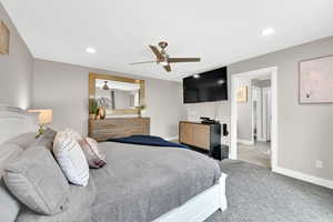 Carpeted bedroom featuring ceiling fan, recessed lighting, and baseboards