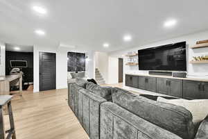 Living room with light wood-style floors, recessed lighting, stairway, and baseboards