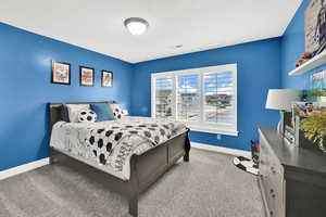 Carpeted bedroom featuring visible vents, a textured ceiling, and baseboards