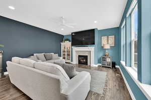 Living area with ceiling fan, recessed lighting, wood finished floors, baseboards, and a tiled fireplace