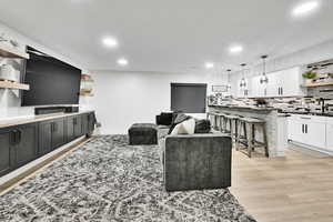 Living area with recessed lighting and light wood-style flooring