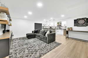 Living room featuring light wood-type flooring, baseboards, and recessed lighting