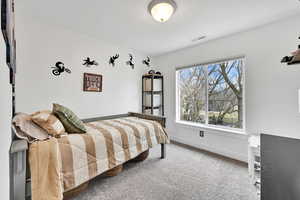 Bedroom with carpet floors, baseboards, and visible vents