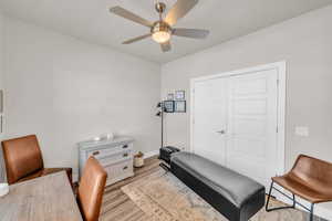 Exercise room with ceiling fan, baseboards, and wood finished floors