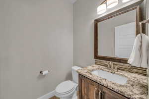 Bathroom featuring vanity, backsplash, toilet, and baseboards