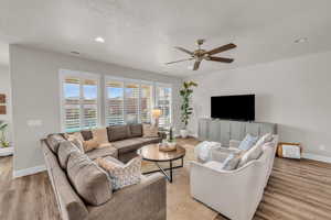 Living room featuring light wood-style floors, visible vents, and baseboards