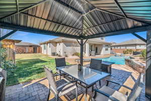 View of patio featuring central air condition unit, a fenced backyard, outdoor dining area, and a gazebo