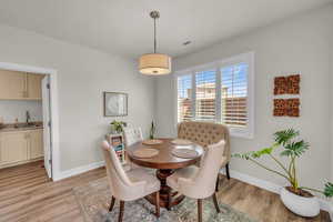 Dining space with visible vents, light wood-style flooring, and baseboards