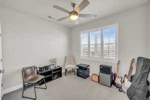 Living area with a ceiling fan, carpet, visible vents, and baseboards