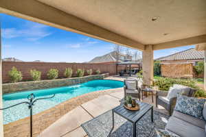 View of pool featuring a patio, a fenced backyard, outdoor lounge area, a gazebo, and a fenced in pool