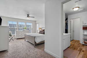 Bedroom featuring baseboards, visible vents, a textured ceiling, and wood finished floors