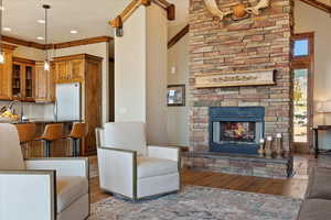 Living area with a stone fireplace, wood finished floors, and recessed lighting