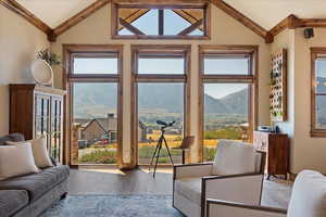 Doorway with lofted ceiling, a mountain view, and wood finished floors