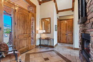 Foyer featuring ornamental molding, a brick fireplace, stone tile floors, and baseboards