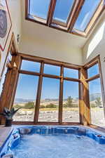 View of pool featuring a skylight and a hot tub