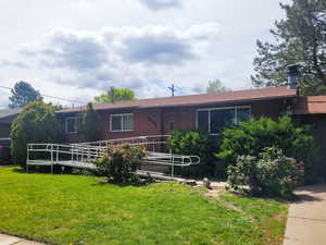 Ranch-style home featuring brick siding and a front yard