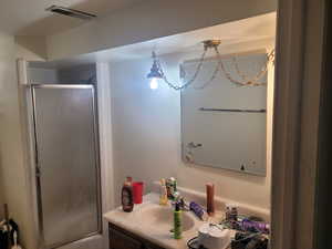 Full bathroom with visible vents, a stall shower, and vanity