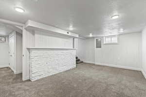 Basement featuring visible vents, stairway, carpet, a textured ceiling, and a bar