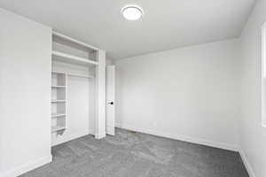 Unfurnished bedroom with a closet, carpet flooring, and baseboards