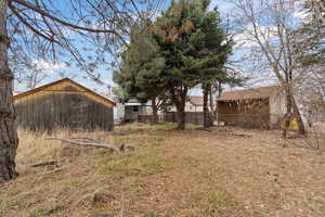 View of yard featuring fence and an outbuilding