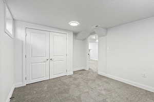 Interior space featuring carpet floors, baseboards, and visible vents