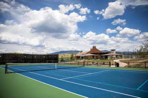 View of tennis court featuring fence and a mountain view