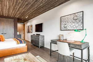 Bedroom featuring wood finished floors, wood ceiling, and baseboards