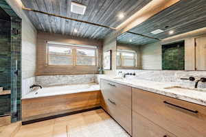 Full bathroom featuring tile patterned floors, a stall shower, a sink, wooden ceiling, and a bath