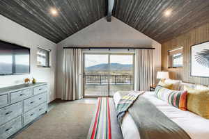 Bedroom featuring vaulted ceiling with beams, wood ceiling, a mountain view, and access to exterior