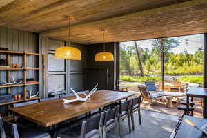 Dining room featuring wood ceiling and concrete flooring