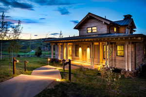 View of front of house featuring a standing seam roof, metal roof, a front lawn, and a porch